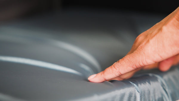 Hand pressing the Gel "E" cushion to show the gel-and-foam give