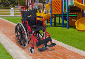 Child's red Wallaby pediatric wheelchair outdoors at a playground
